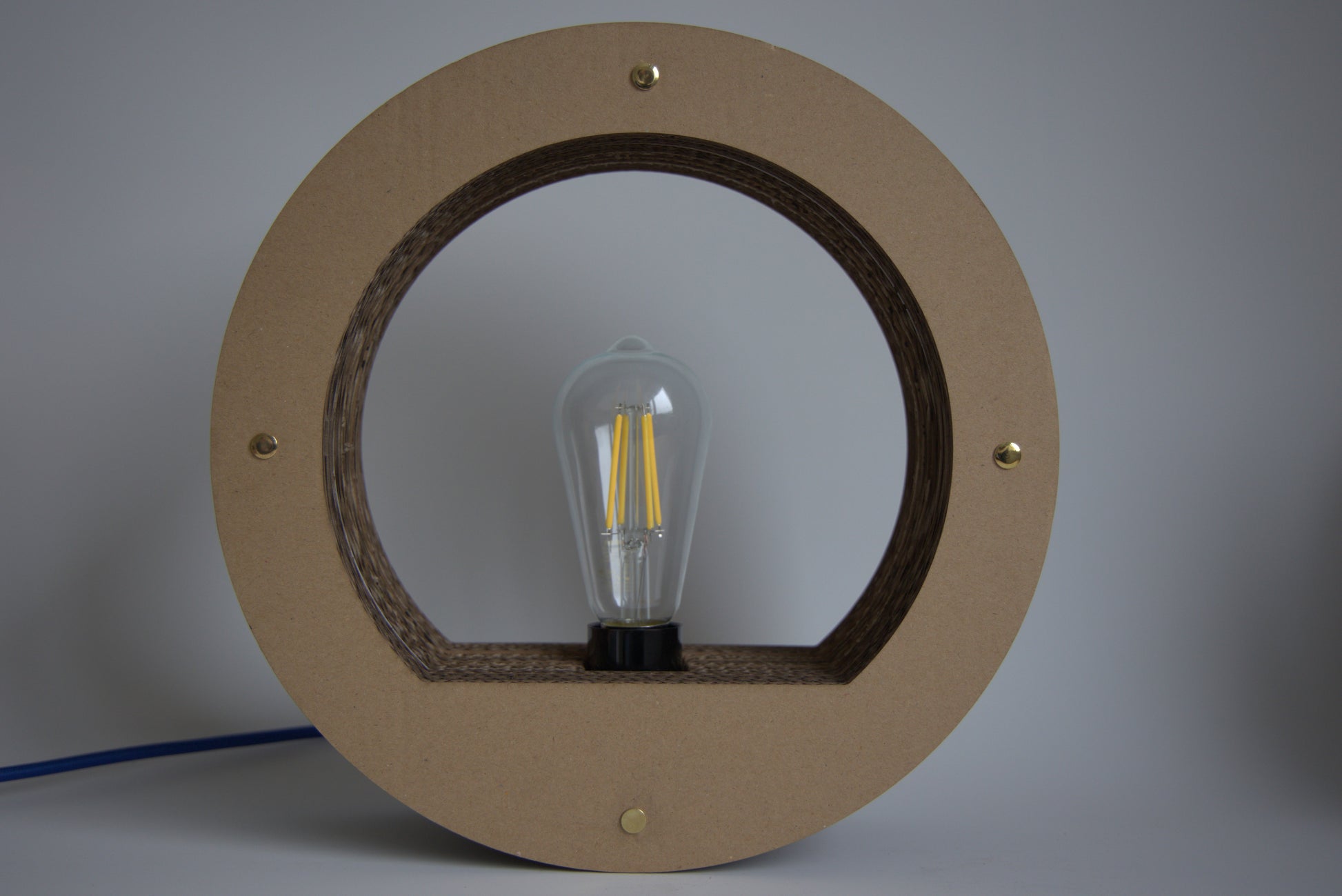 Détail de la matière recyclée, du carton, utilisée pour la fabrication de la lampe ronde Promis.